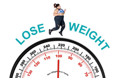 Digital composite image of woman running over weight scale with text against white background