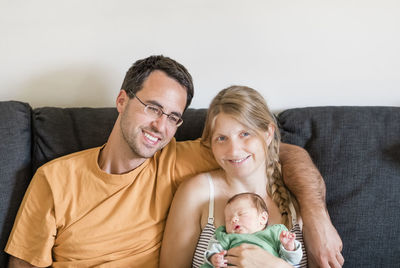 Happy family sitting on sofa at home