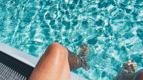 Low section of men in swimming pool