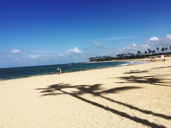 Scenic view of beach against blue sky