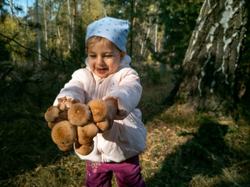 Portrait of young woman standing in forest