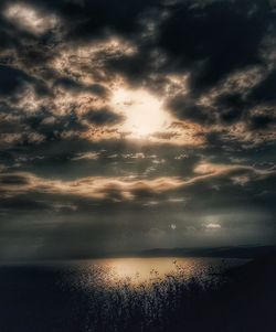 Scenic view of sea against cloudy sky at sunset