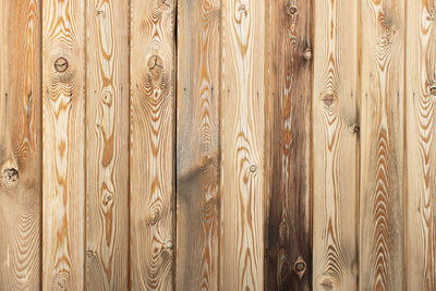 Wooden decorative background with place for text. light brown larch boards with knots and holes