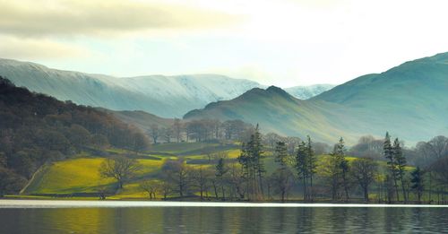 Scenic view of lake and mountains against sky