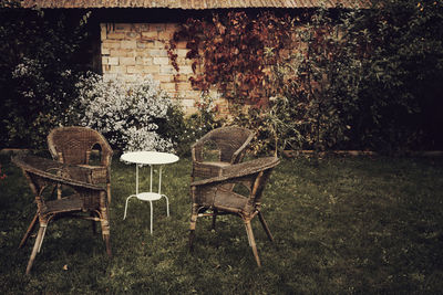 Empty chairs and table in yard