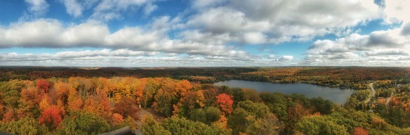 Panoramic view of lake surrounded by plants against cloudy sky