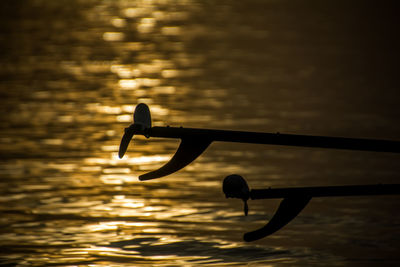 Silhouette of boat in sea against sky during sunset