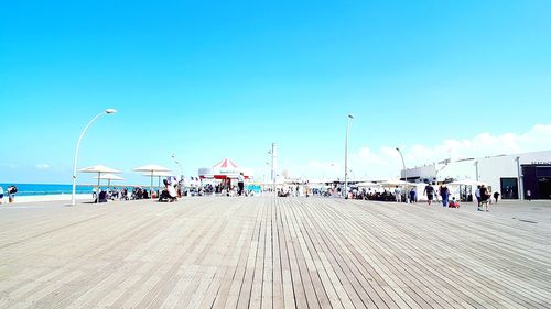 Crowd on promenade against blue sky