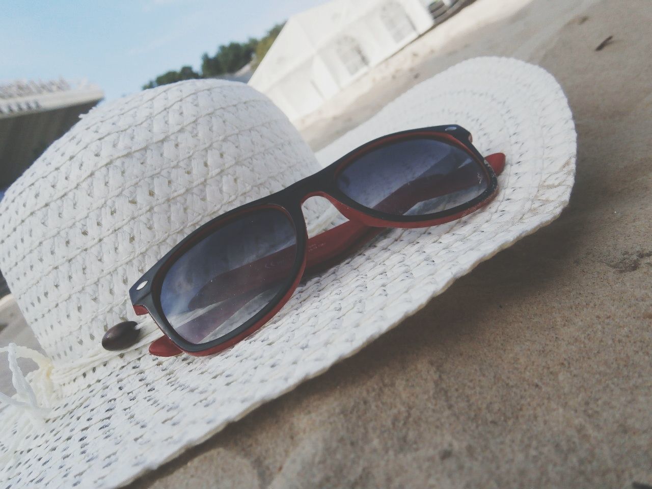 building exterior, sunglasses, close-up, architecture, built structure, day, focus on foreground, table, no people, sunlight, car, still life, outdoors, part of, high angle view, reflection, selective focus, technology, retro styled, shadow