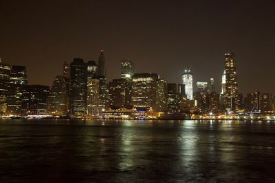 Illuminated buildings in city against sky at night