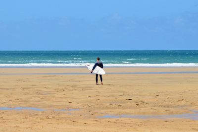 Full length of man standing on beach against clear sky