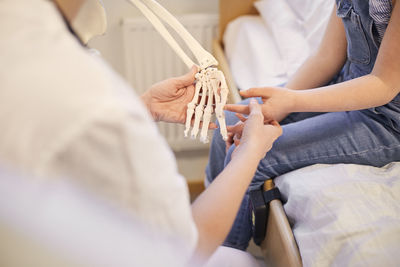 Female doctor examining girls hands