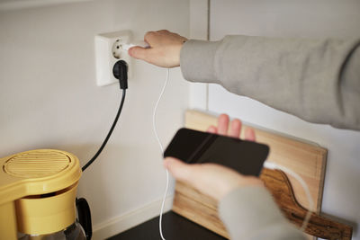 Hands plugging in cell phone charger