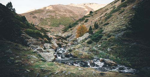 Scenic view of river amidst mountains against sky