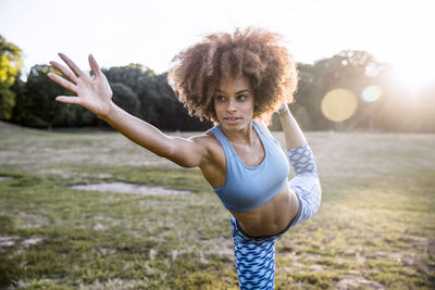 Woman exercising in park during sunset