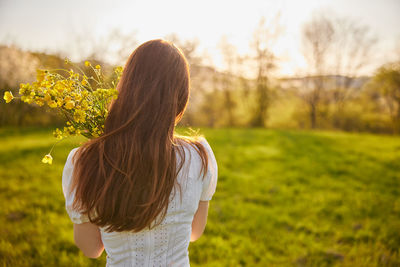 Rear view of woman standing on field