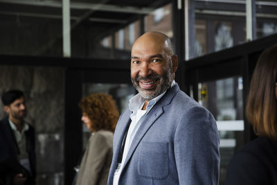 Portrait of smiling businessman in blue blazer at seminar