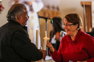 Cheerful woman talking to senior man in auditorium