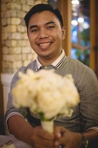 Portrait of smiling man holding flower bouquet