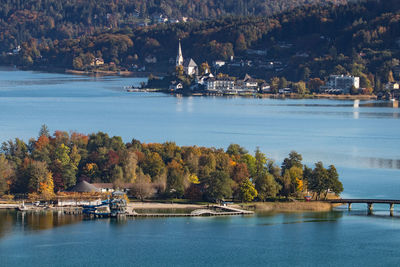 Scenic view of river by trees and buildings during autumn