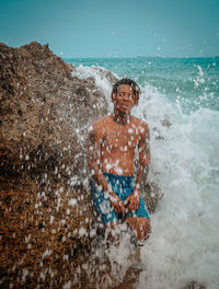 Young man splashing water in sea