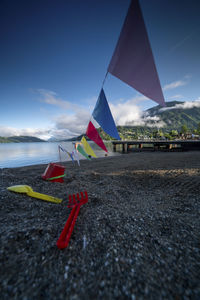 Multi colored flag on beach against sky