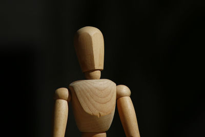 Close-up of figurine on table against black background