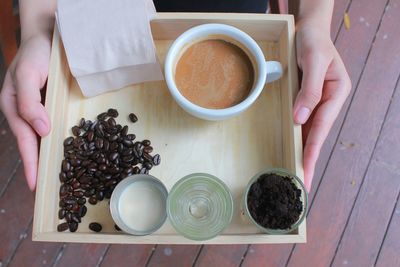 High angle view of coffee cup and beans on tray