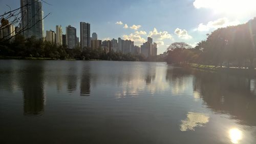 Scenic view of river by buildings against sky