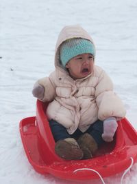 Cute baby girl sitting on sled
