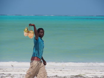 High angle view of woman standing by sea