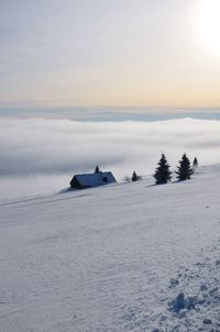 Scenic view of snow covered land against sky during sunset