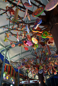 Low angle view of lollipops and candies hanging on tree structure in market