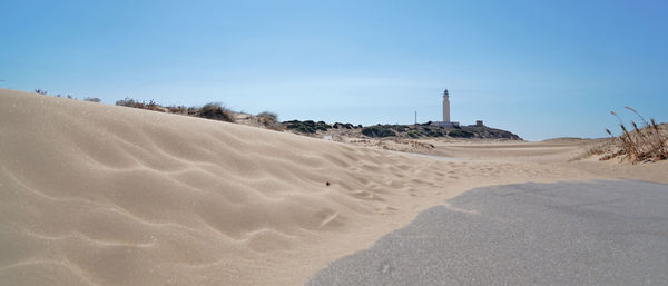 Sand dunes in desert against clear blue sky