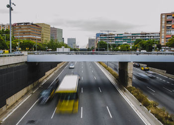 Road by bridge in city against sky