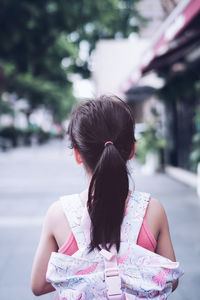 Rear view of woman looking at camera