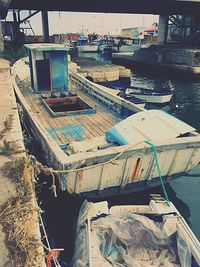 Abandoned boats moored at harbor