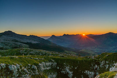 Scenic view of mountains against clear sky during sunset