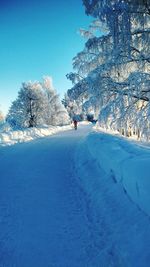 Snow covered landscape against blue sky