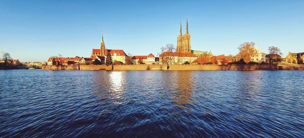 River by buildings against sky in city