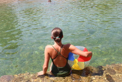 Rear view of shirtless man in sea