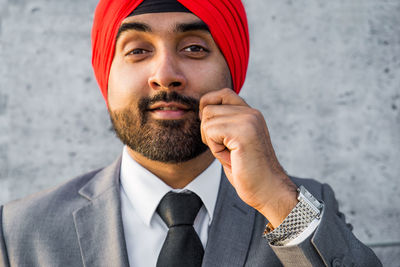 Close-up of businessman holding mustache while standing outdoors