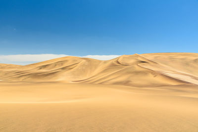 Scenic view of desert against clear blue sky