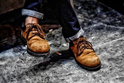 Low section of man wearing shoes sitting outdoors