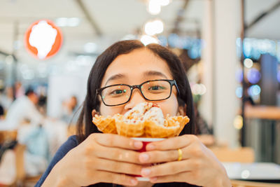 Portrait of woman holding ice cream in restaurant