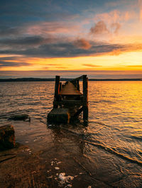 Scenic view of sea against dramatic sky during sunset