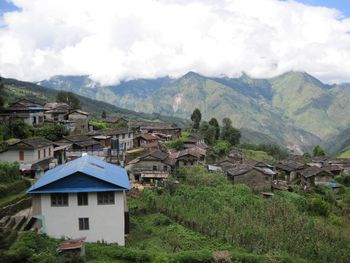 Houses by buildings against sky