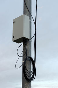 Low angle view of telephone pole against sky