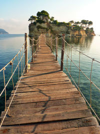 View of jetty leading to island in sea