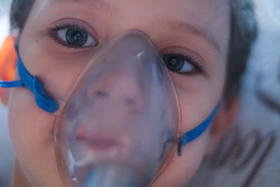 Close-up portrait of boy wearing oxygen mask